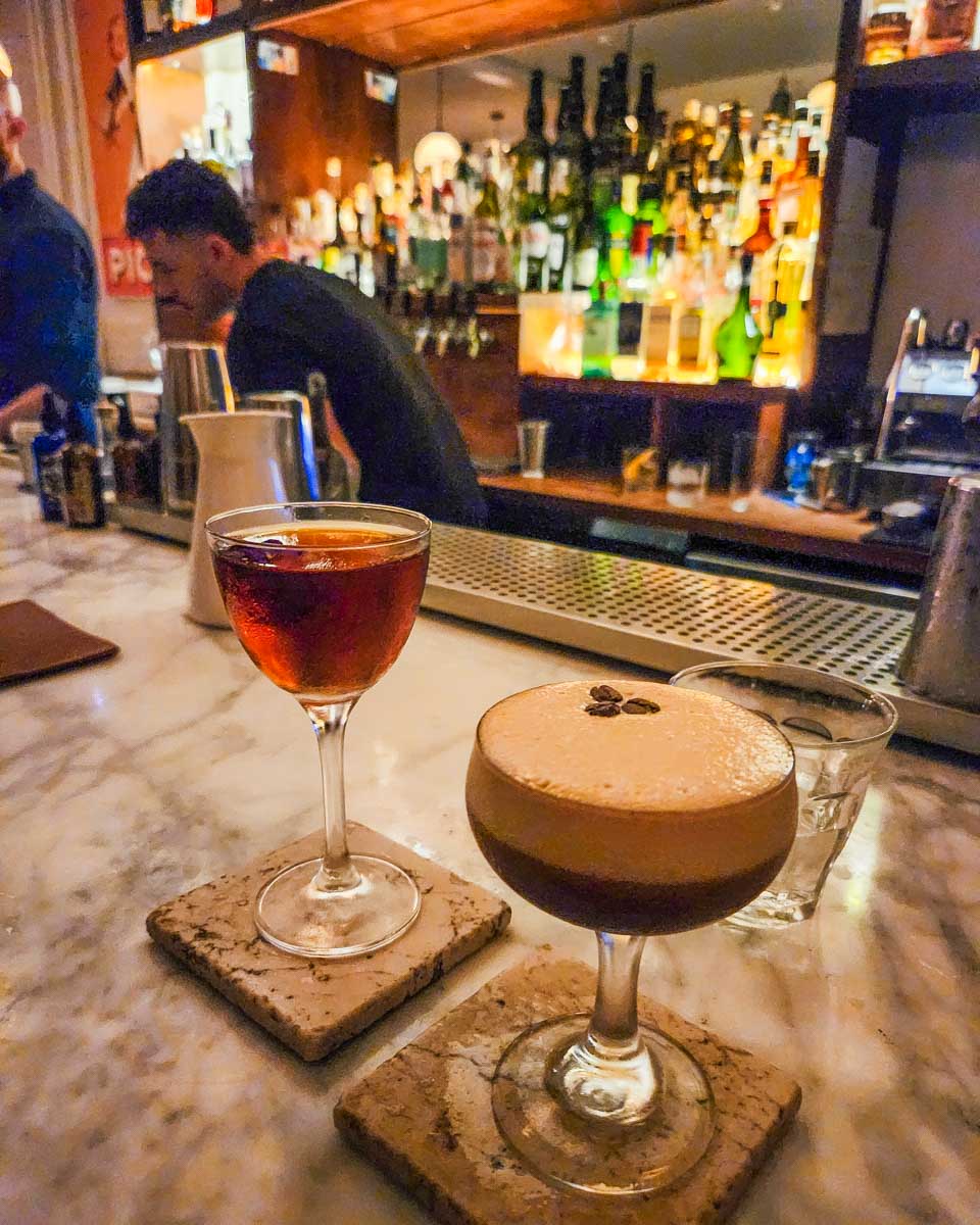 Two cocktails at the bar at Pompette Bar in Toronto