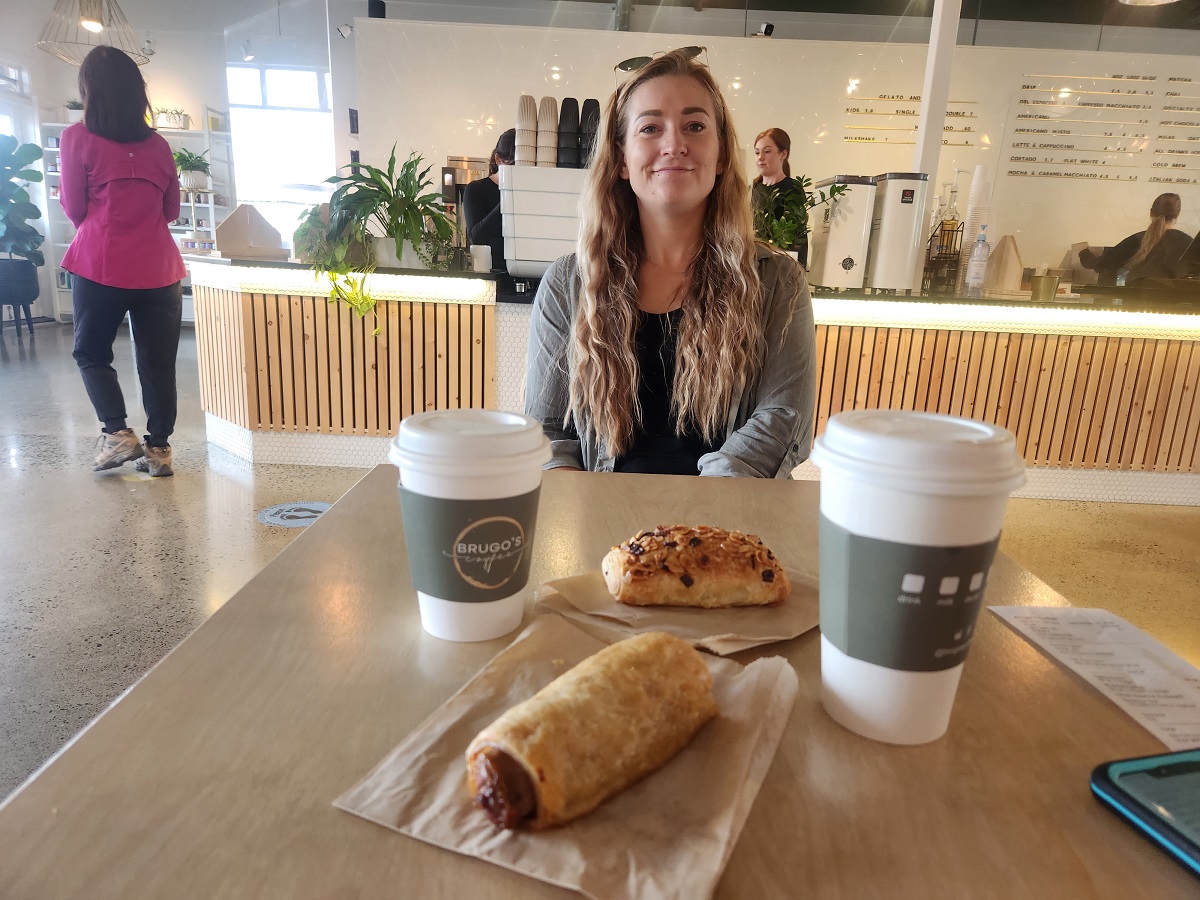 Bailey sits at a table at BruGos coffee with coffees and snacks