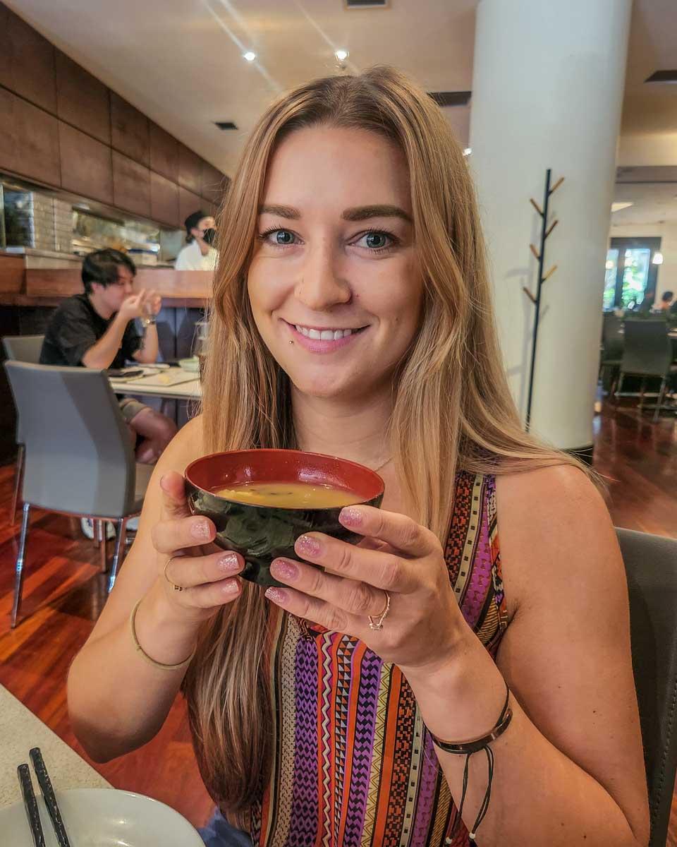 Bailey eats miso soup at Miku in Toronto