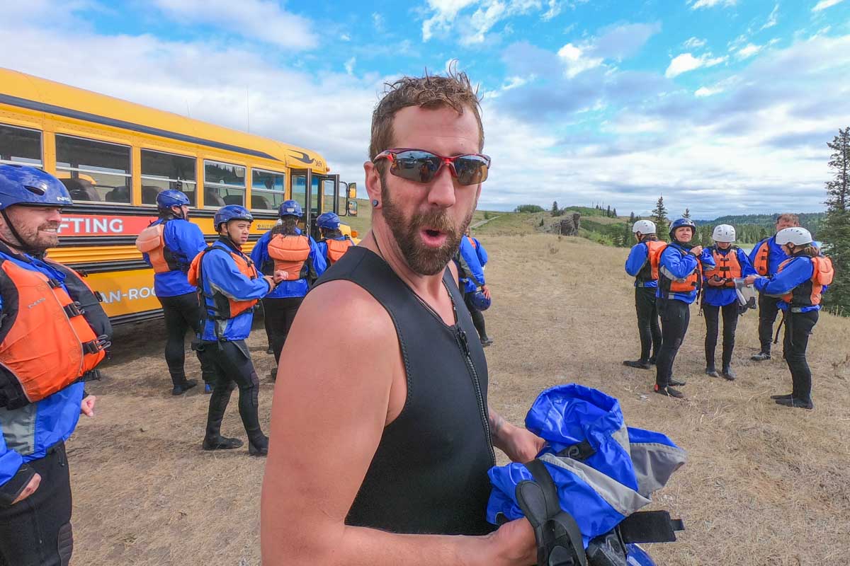 A man poses for a photo in his white water rafting gear after the tour in Banff