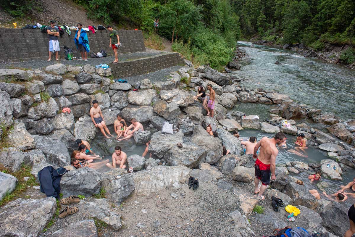 many people sitting inside the lussier hot springs near fairmont bc