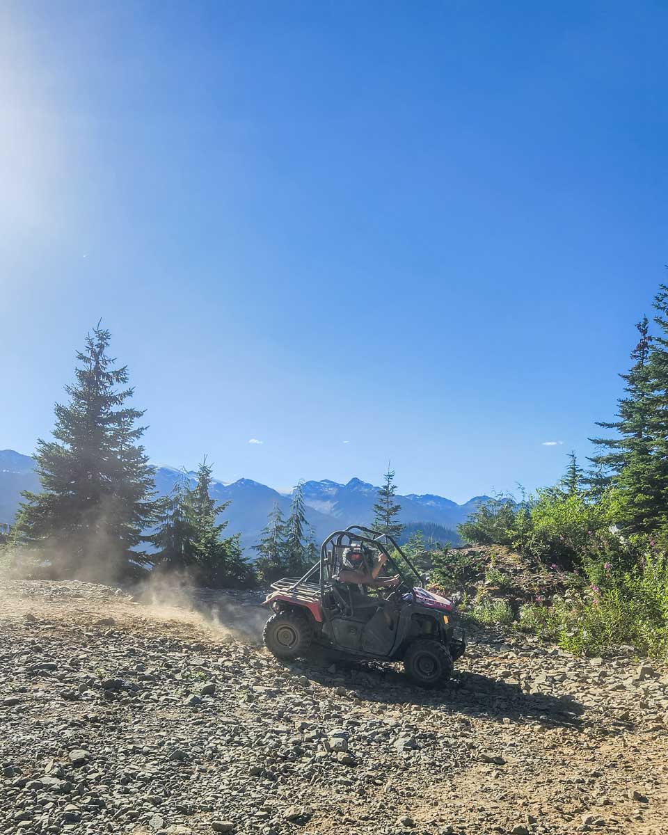 Two people ride a side by side ATV in Whistler