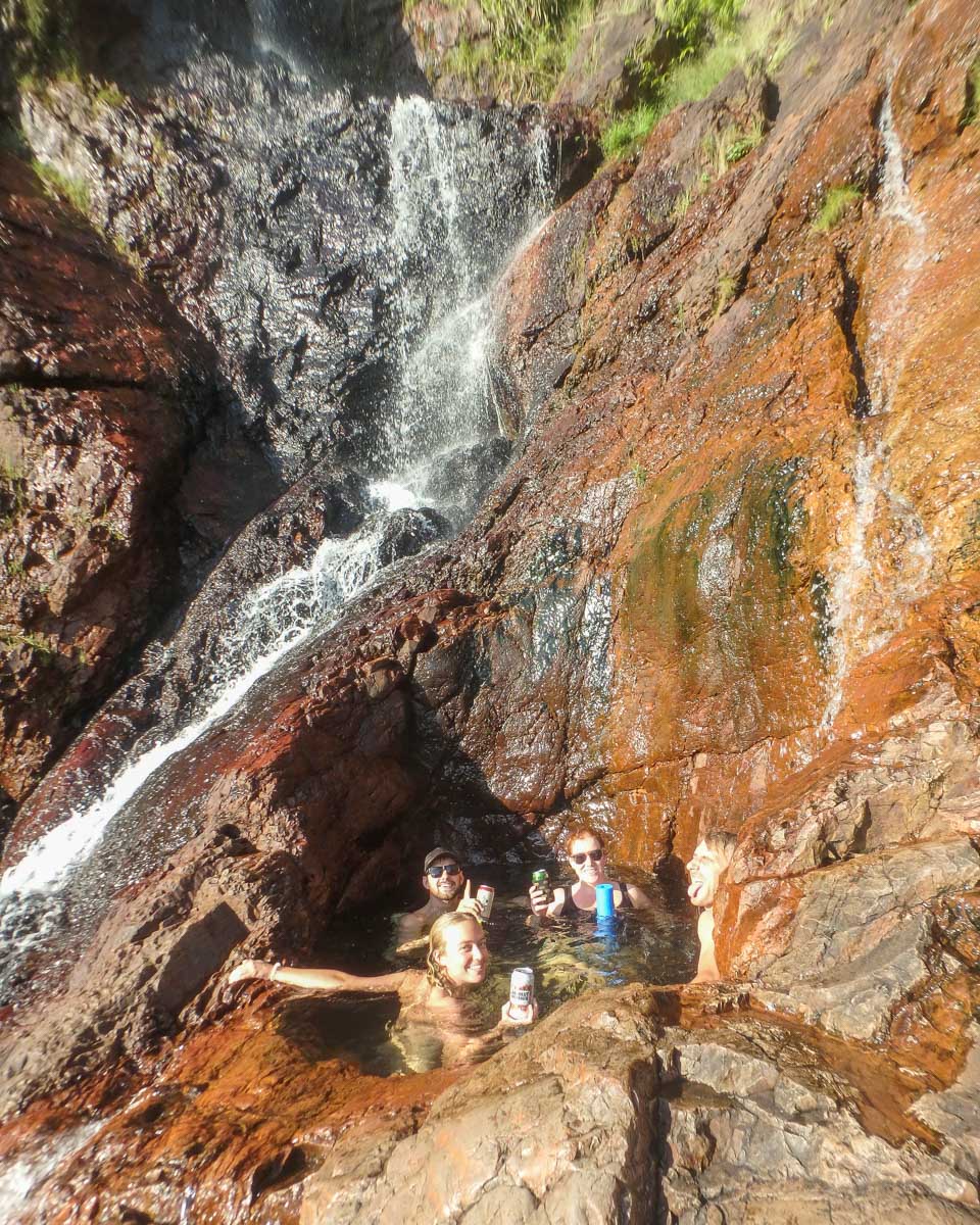 A group of people in the secret rock pool at Wangi Falls