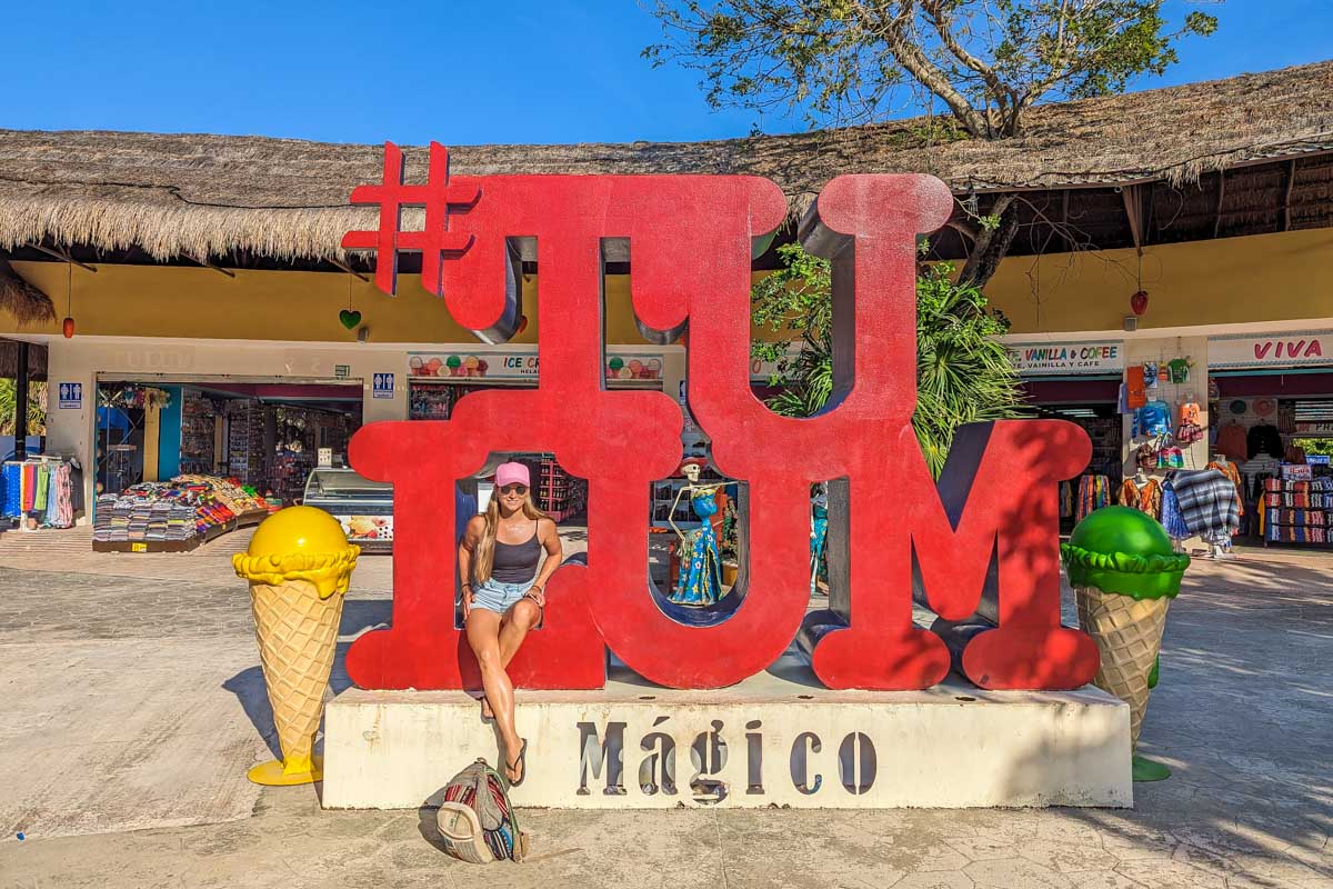 Bailey poses for a photo with the Tulum sign at the entrance to the Tulum Ruins