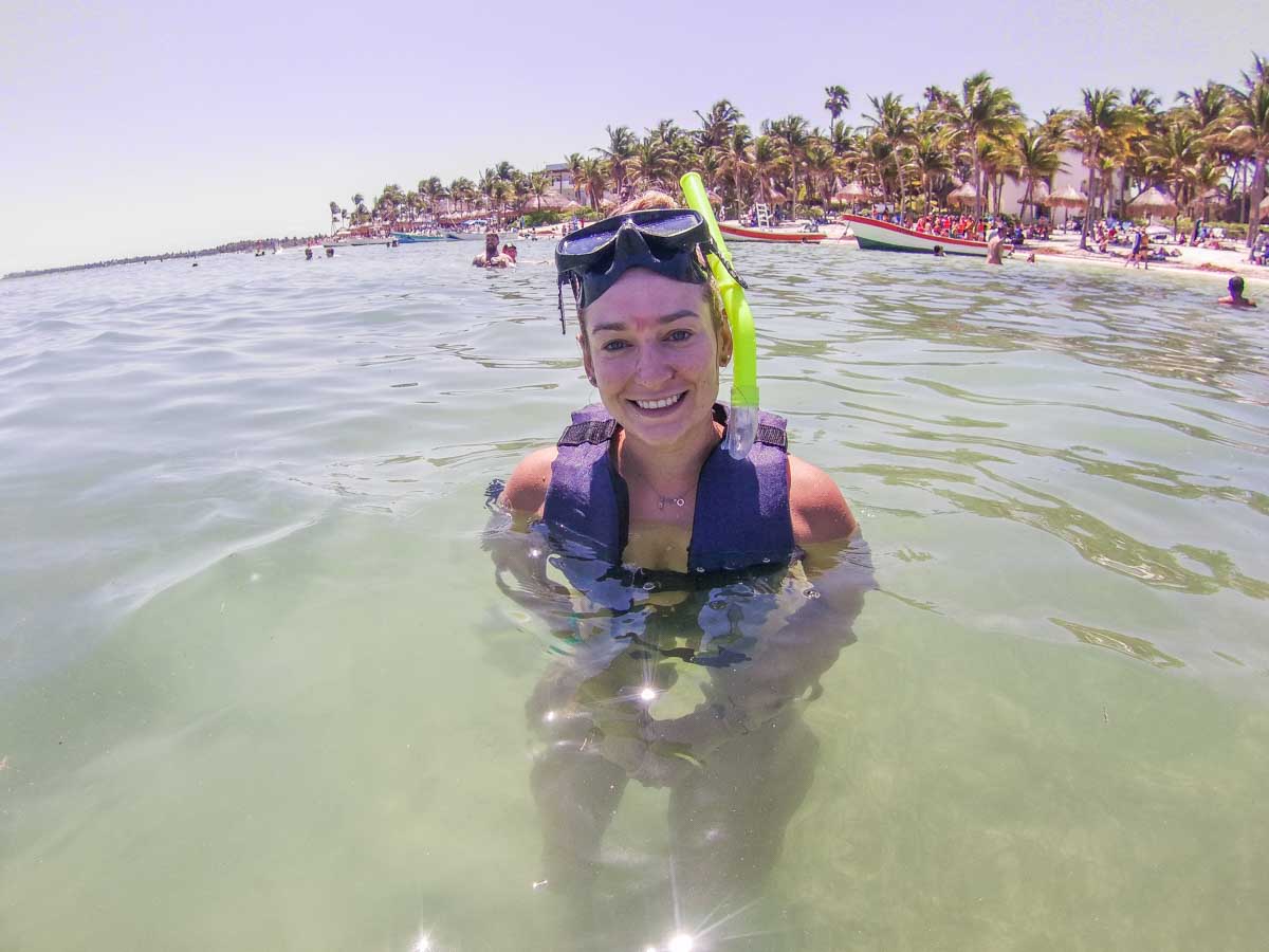 Bailey takes a break from snorkeling while at Akumal Beach and smiles at the camera while in the water
