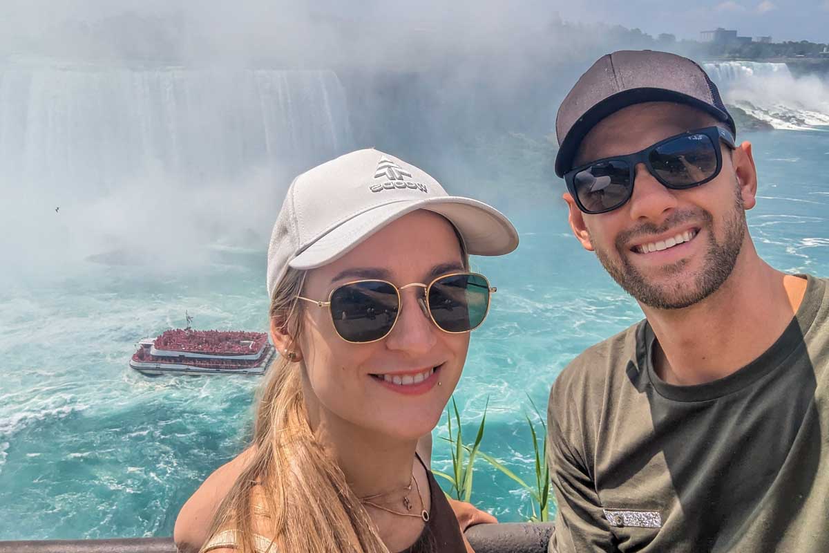 Daniel and Bailey take a selfie at Niagara Falls as the Hornblower Cruise heads past below them