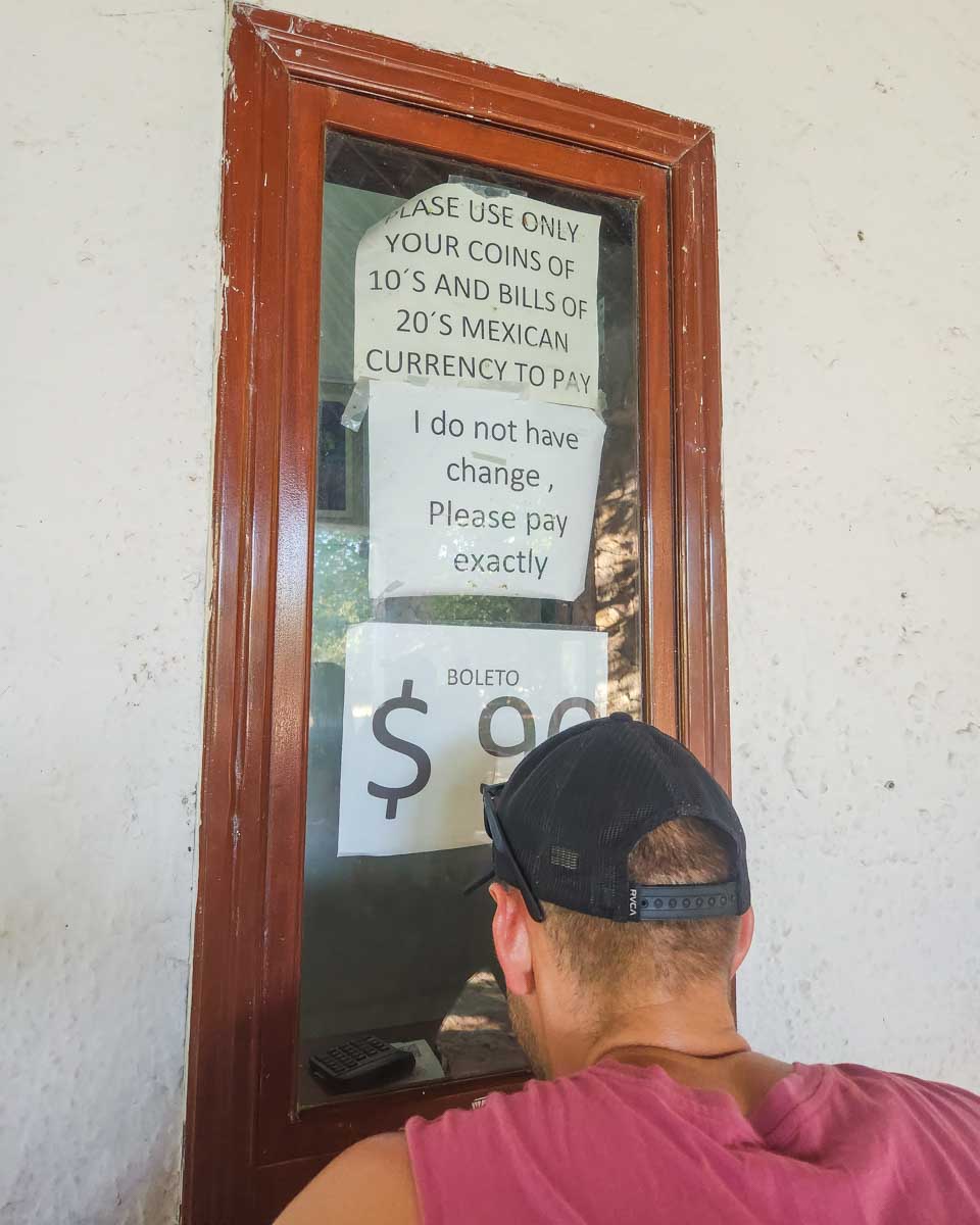 Daniel buys our tickets from the ticket booth at the Tulum Ruins in Tulum, Mexico