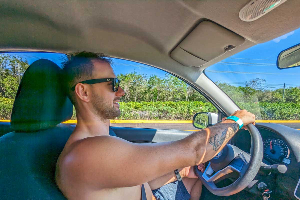 Daniel drives along the highway in a rental car in Mexico