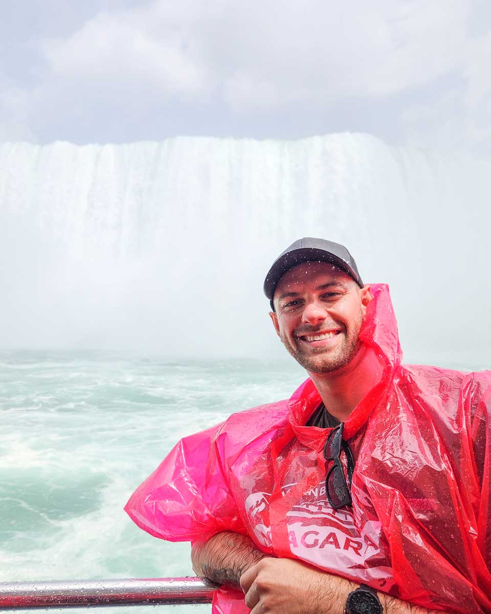 Daniel poes for a photo at the front of the boat on the Hornblower Cruise in Niagara Falls