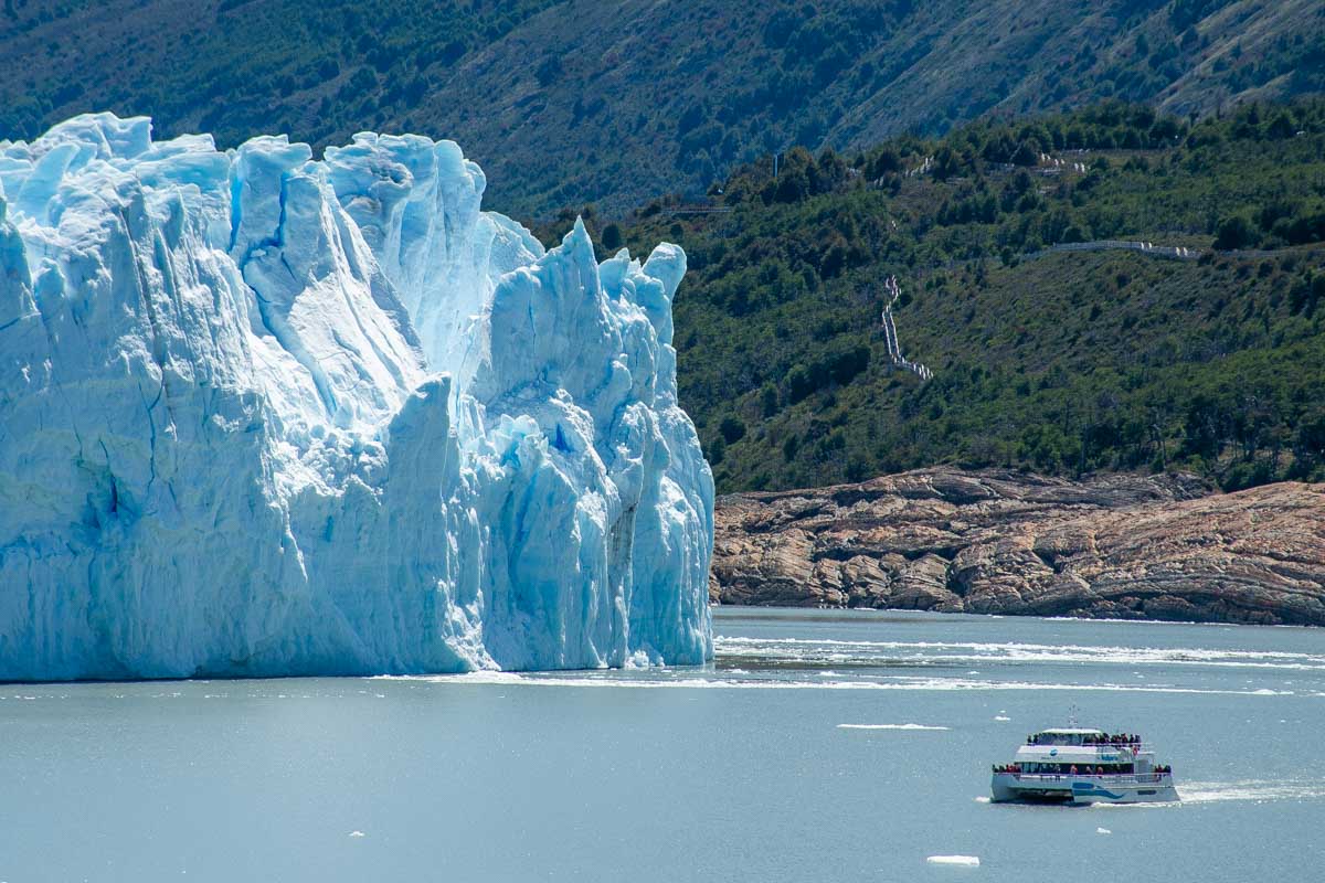 A boat cruises along the face of the Perito Moreno Glacier on a navigation tour