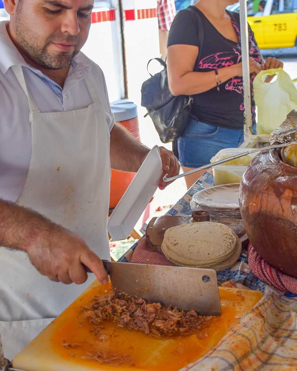 A man chops meat for tacos in Mexico City, Mexico