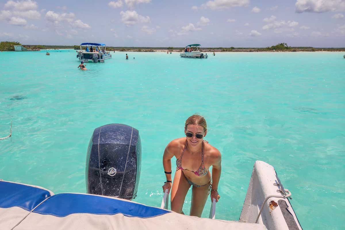 Bailey climbs into our boat at Canal de los Piratas in Bacalar Lagoon on a boat tour