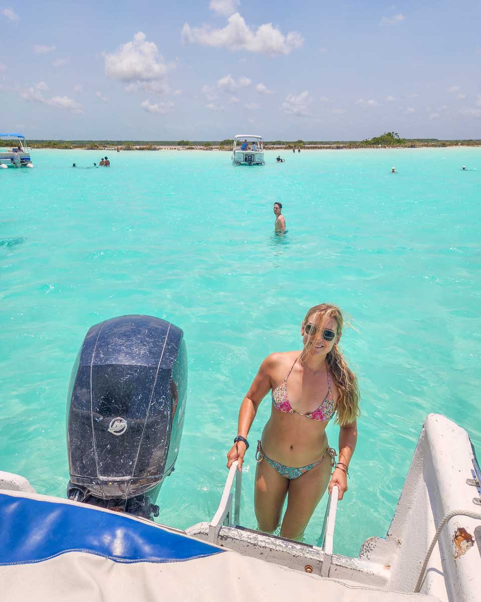 Bailey climbs into the boat on a Bacalar boat tour in Mexico