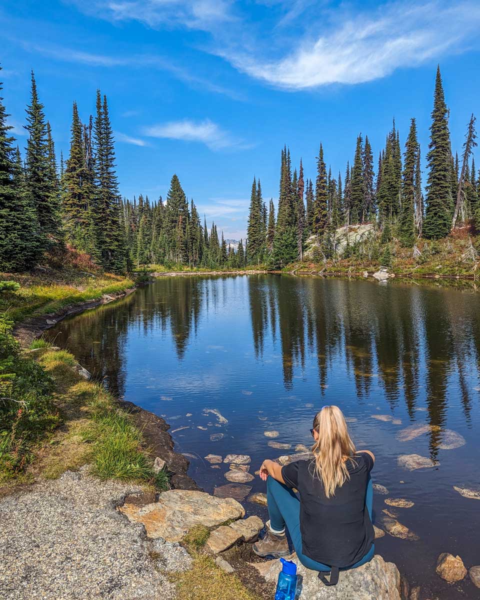 Bailey sits by a lake in Mount Revelstoke National Park