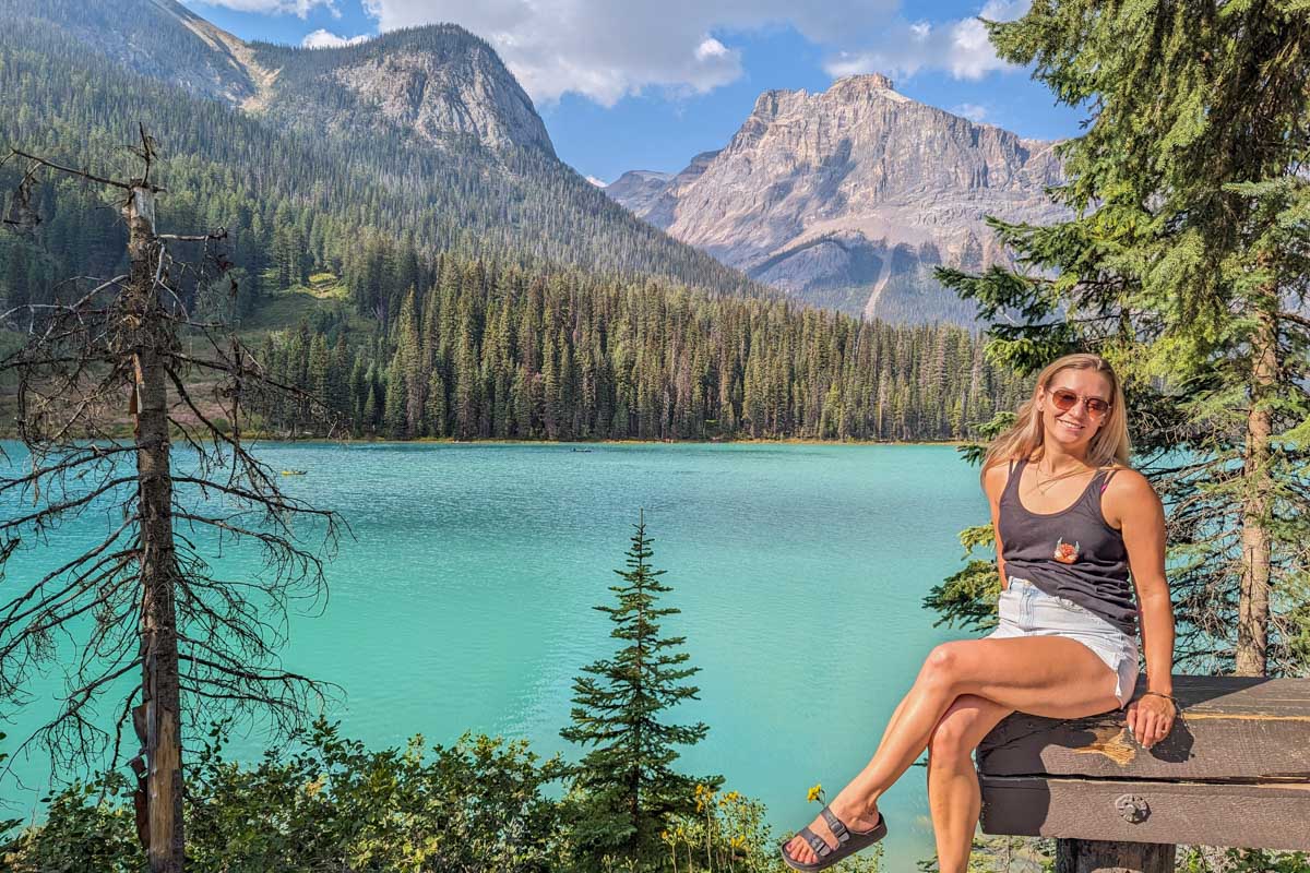 Bailey sits on a railing and poses for a photo at Emerald Lake in Yoho National Park