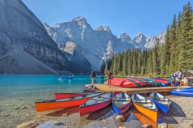 Canoes sit in the water at Moraine Lake, Banff National Park