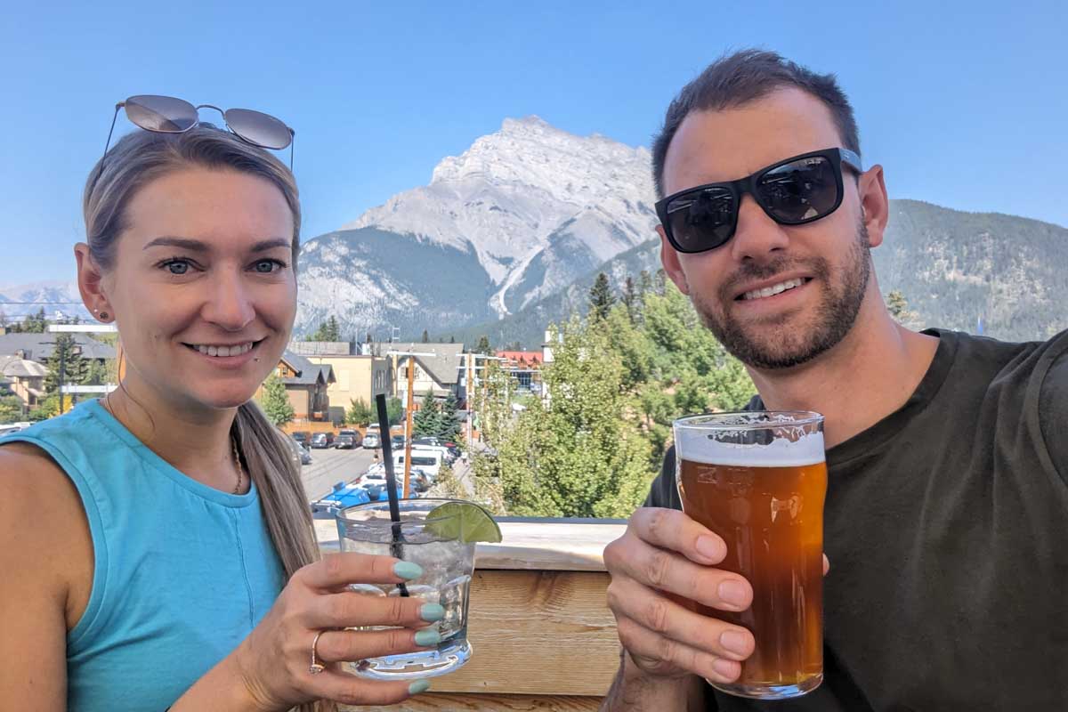 Daniel and Bailey take a selfie ith drinks on a rooftop bar in Banff, Canada