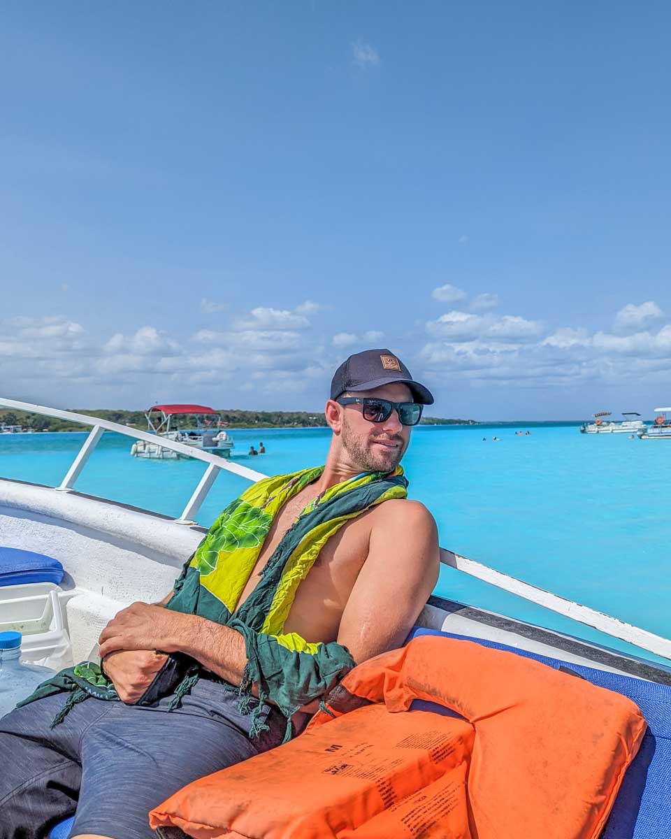 Daniel sits on a boat in Bacalar Lagoon, Mexico
