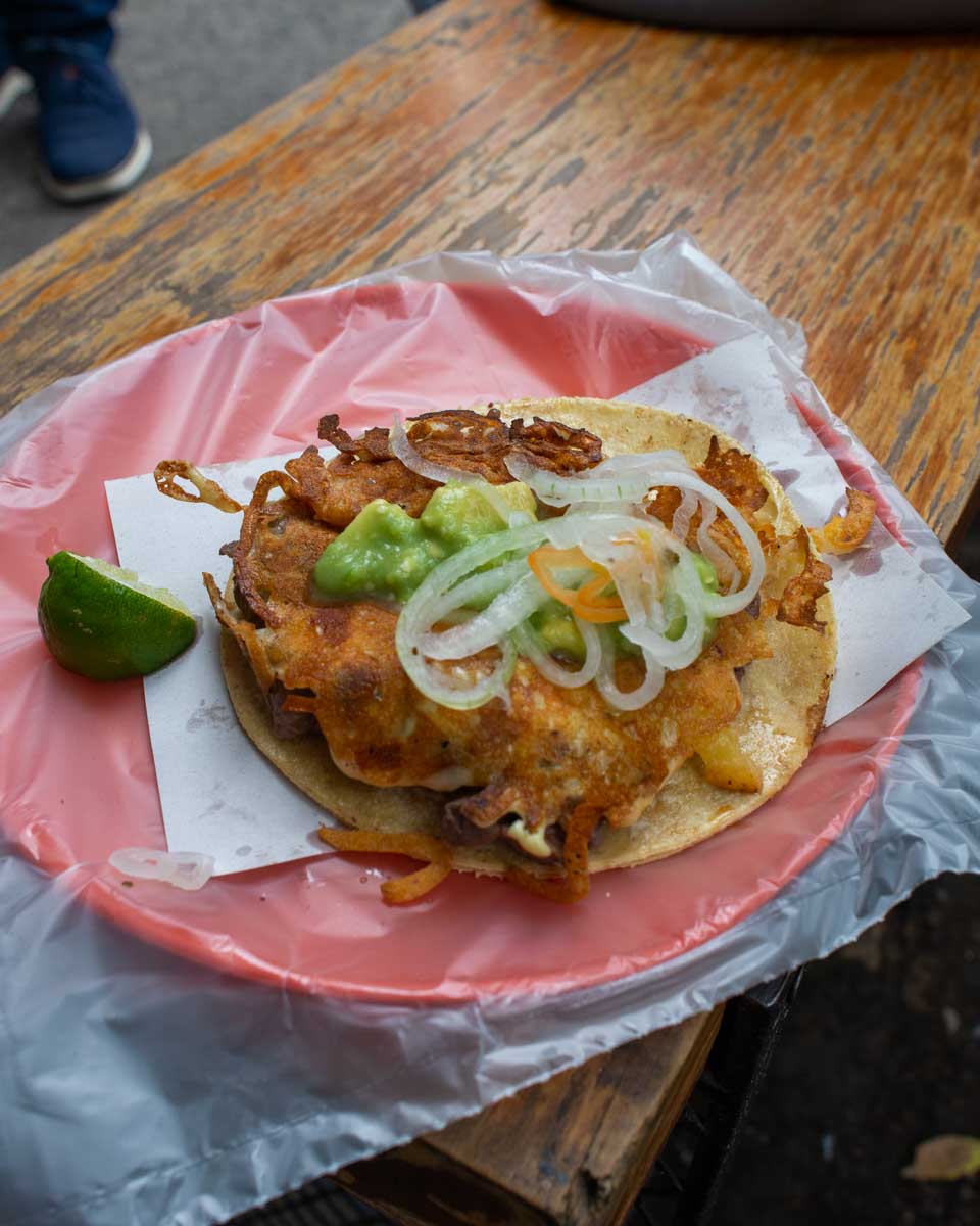 Meat taco with grilled cheese on top in Mexico City