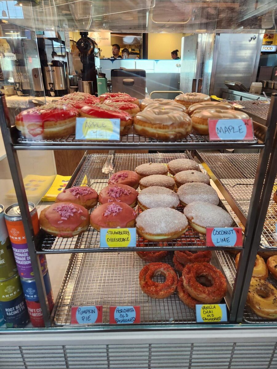 a selection of donuts on display for sale at the farmer's market