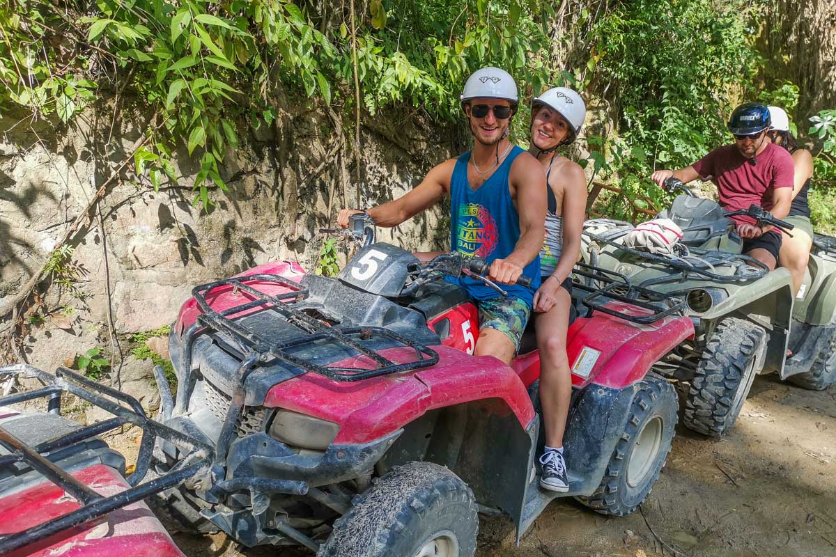 Two people sit on an ATV ready to start the tour