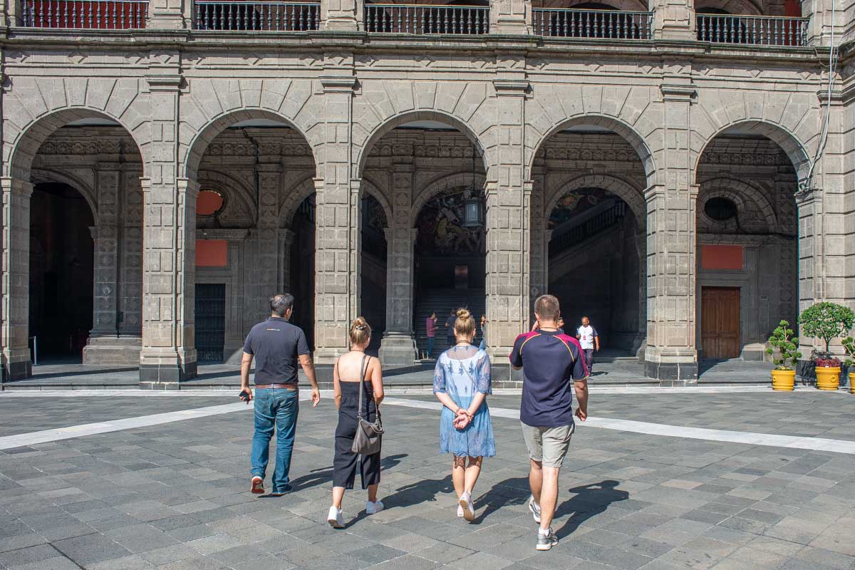A group of tourists walk around the National Palace in Mexico City!