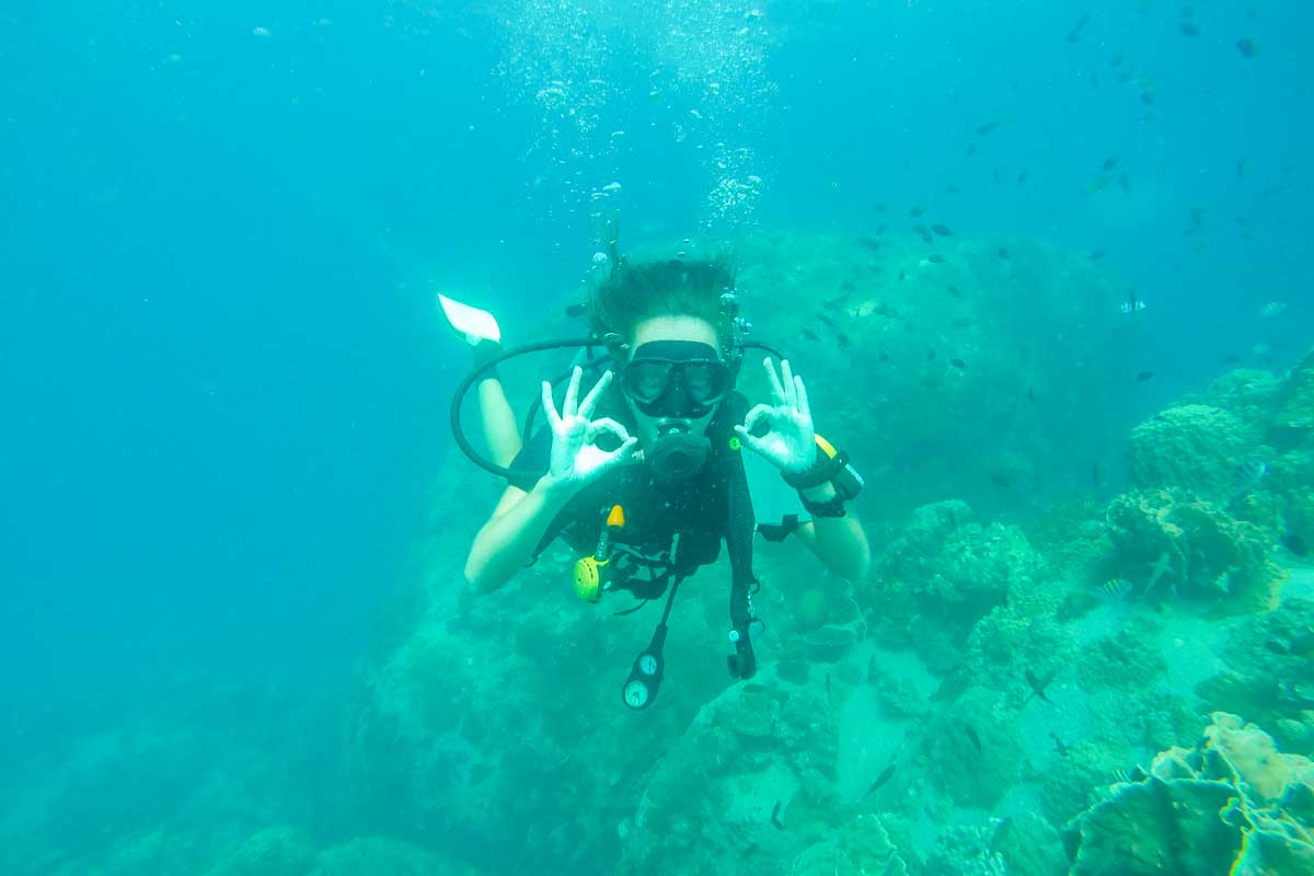 A lady gives the ok sign while scuba diving in Puerto Vallarta