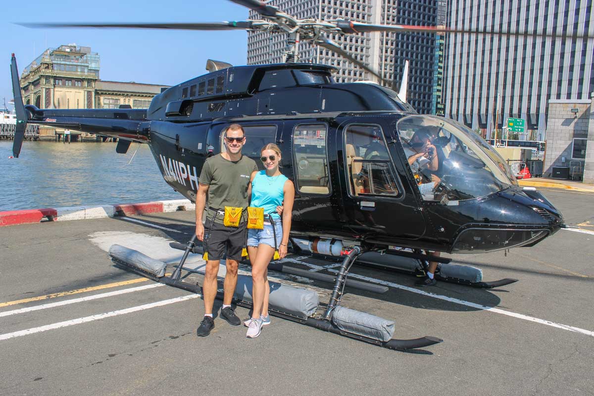 Bailey and Daniel stand in front of their helicopter in Manhattan, New York City