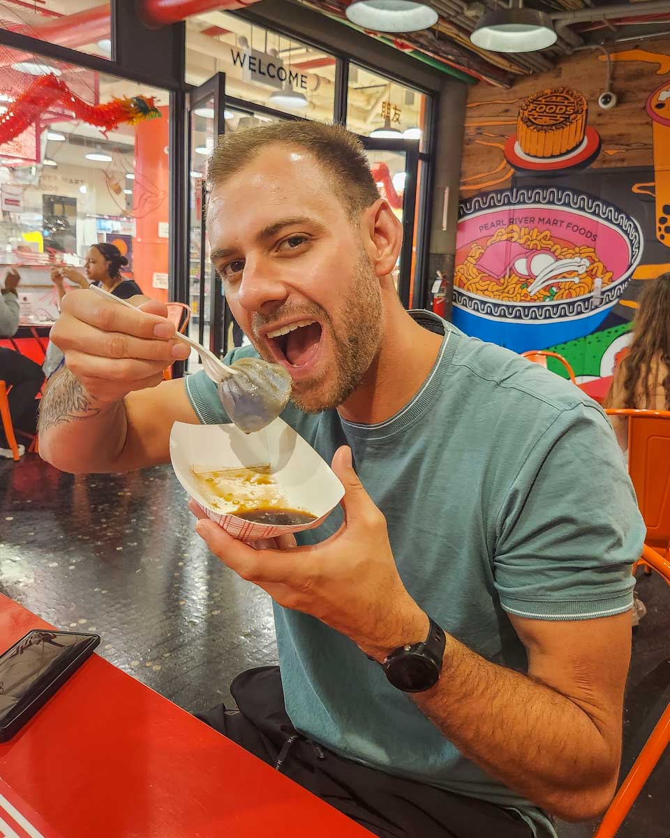 Daniel eats his Bao on our Chelsea Market food tour in NYC