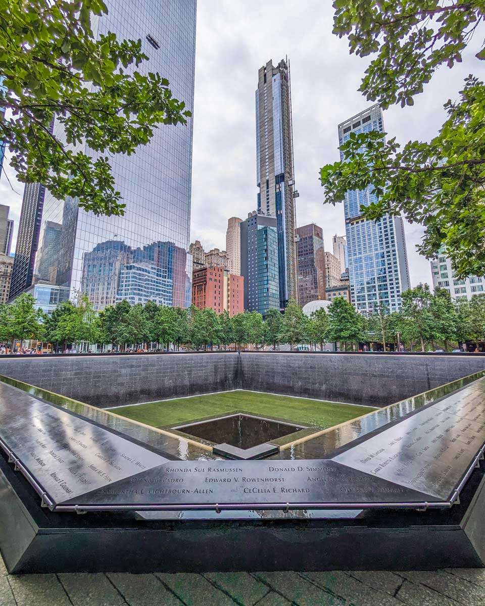 The 911 Memorial and Museum outside Memorial with the skyline of NYC in the background