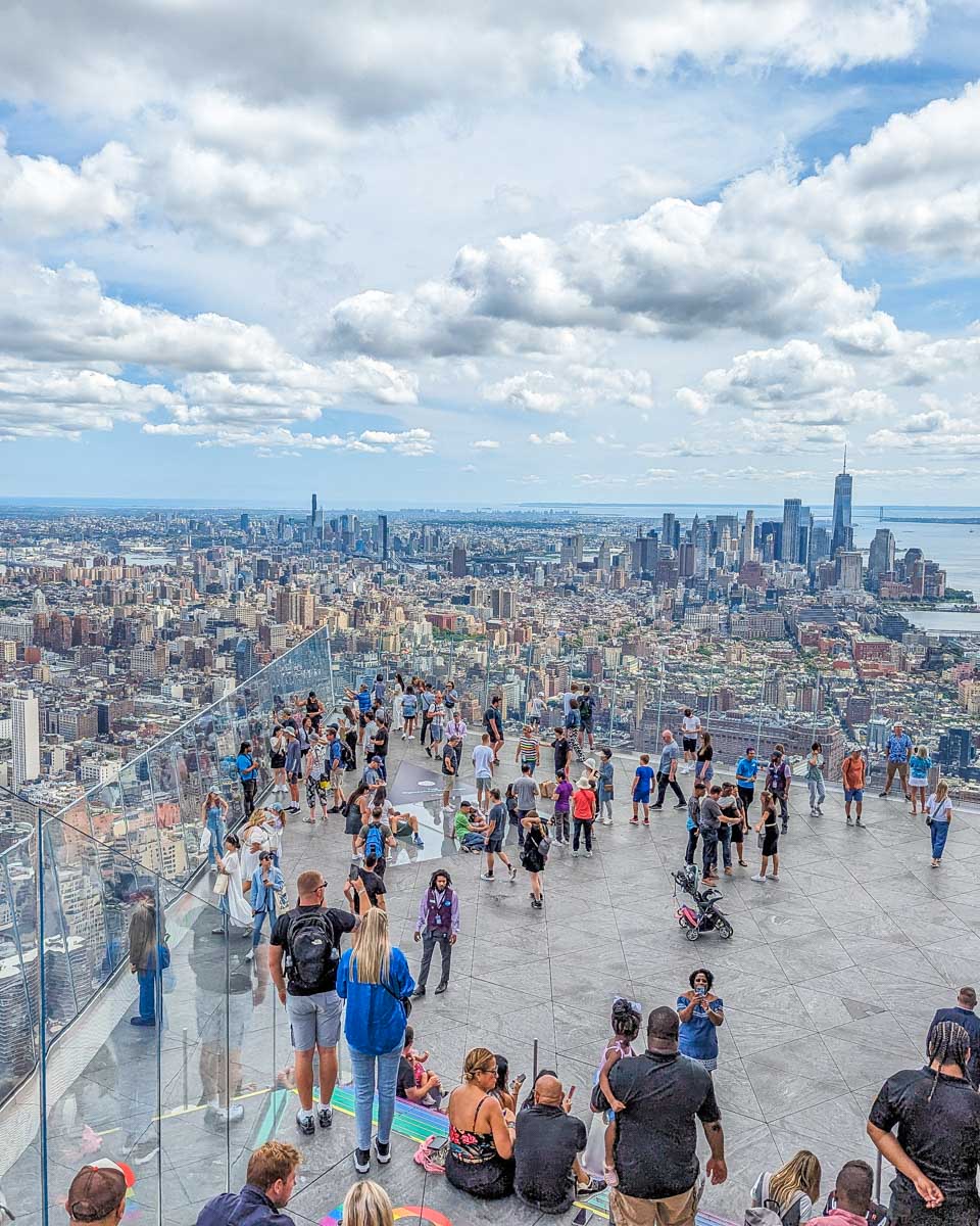 Tourists enjoy the outdoor balcony at the Edge in New York City with the city in the background