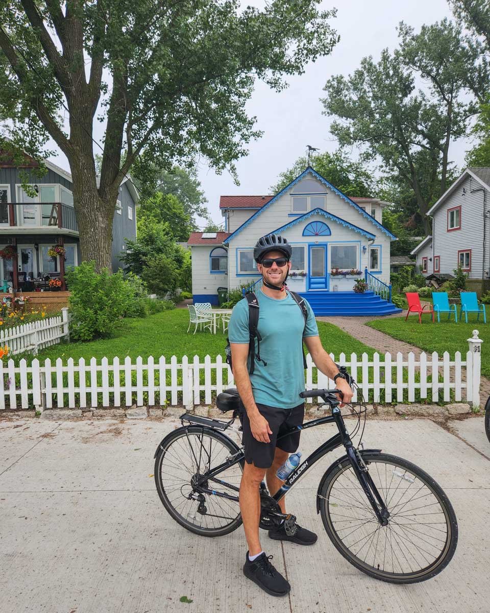 Daniel poses for a photo in front of a cute house on the Toronto Islands, Canada