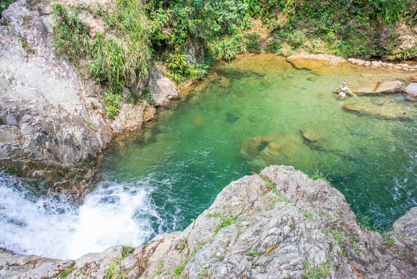 A lady swims in a waterfall in San Rafael, Colombia