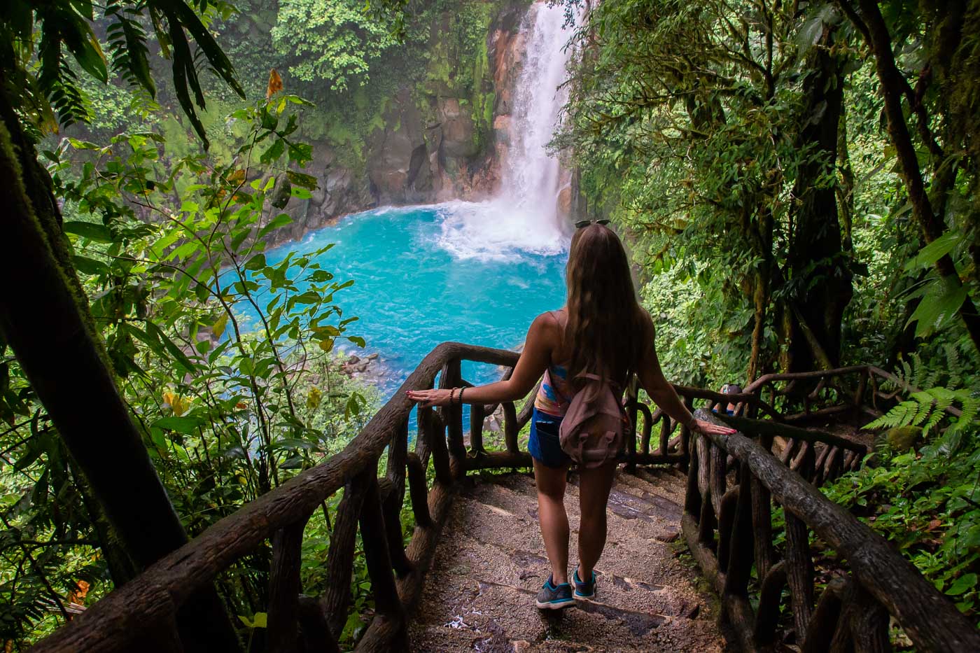 A lady walks down the steps to Rio Celeste in Costa Rica