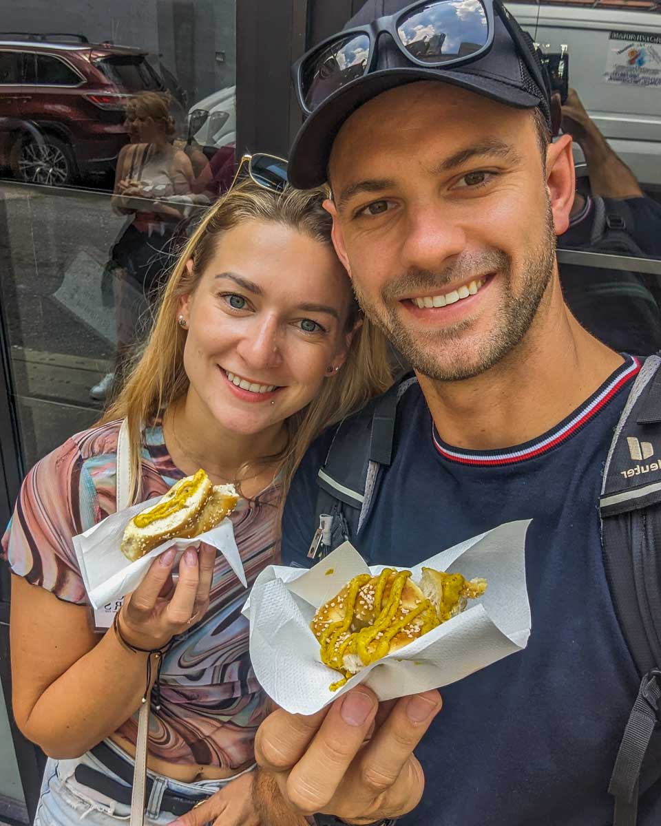 Bailey and Daniel take a selfie with their fresh pretzels during a food tour in Philadelphia, USA