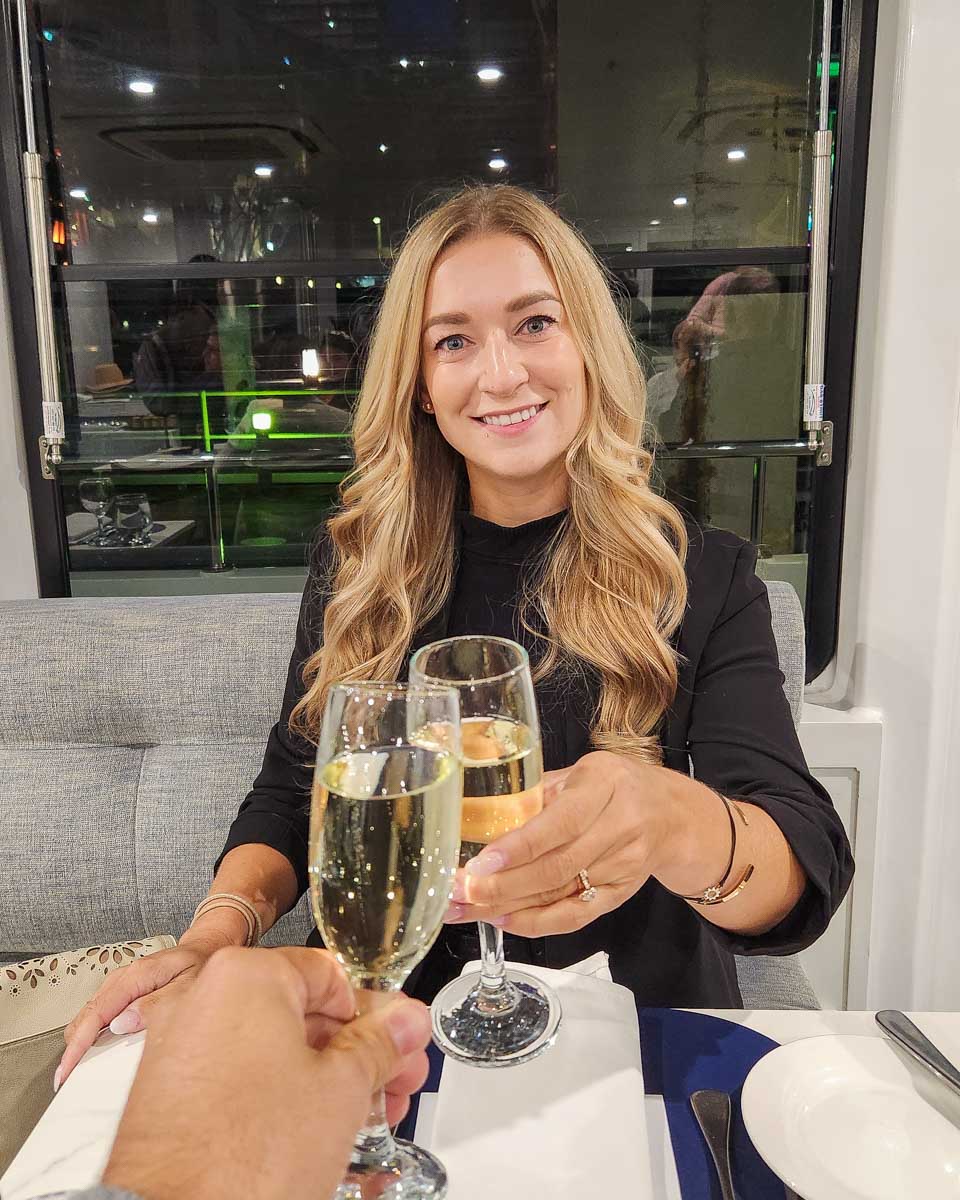 Bailey does a cheers with champagne on the Journey Beyond the Cruise Sydney