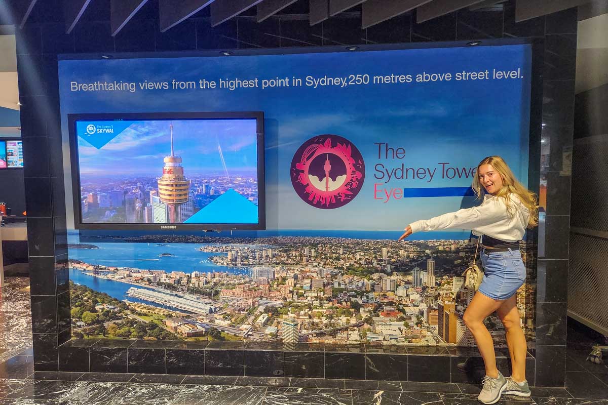 Bailey poses for a photo at the sign at the entrance of the Sydney Tower Eye in Sydney, Australia