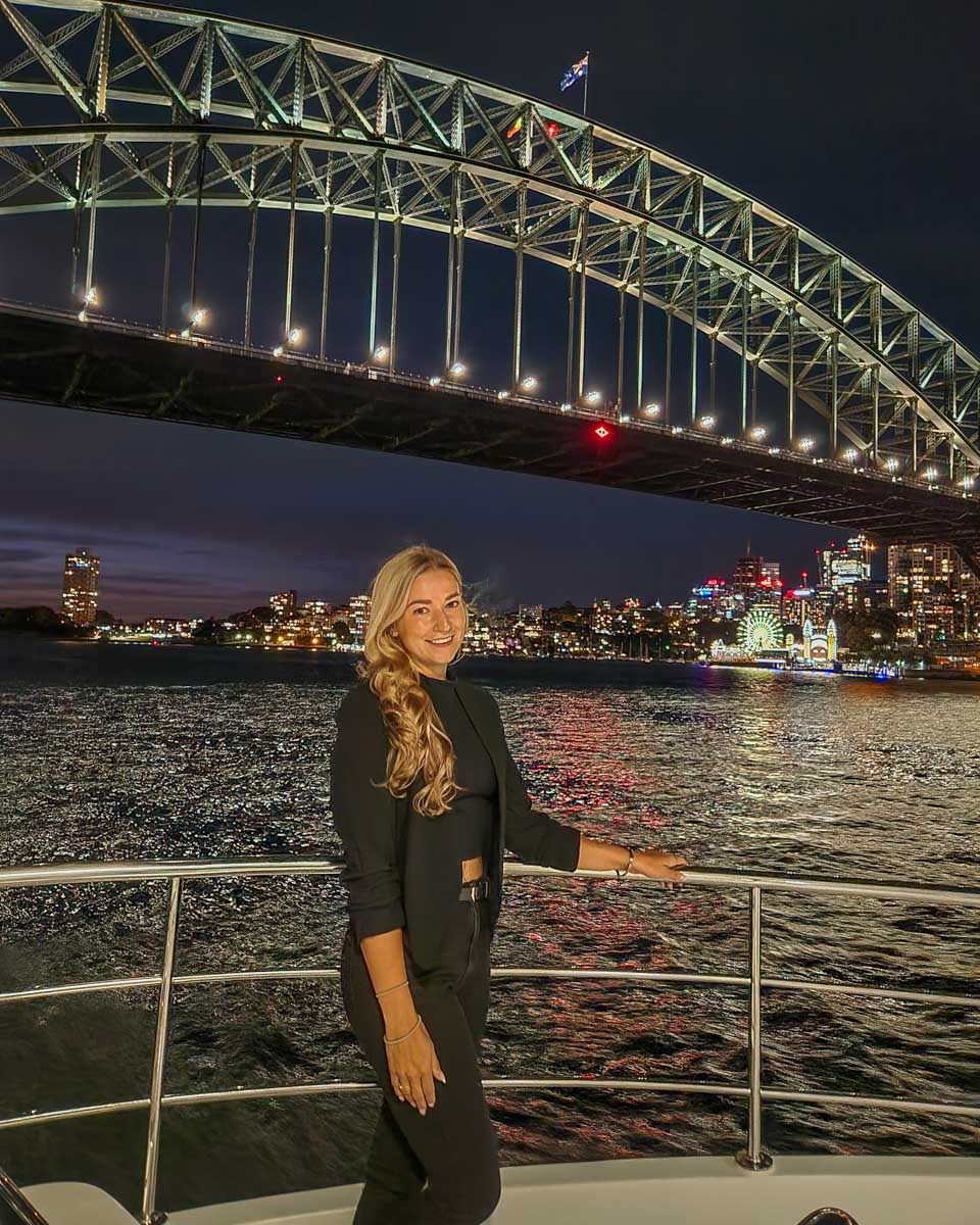Bailey poses for a photo with the Sydney harbour Bridge during a dinner cruise in Sydney, Australia