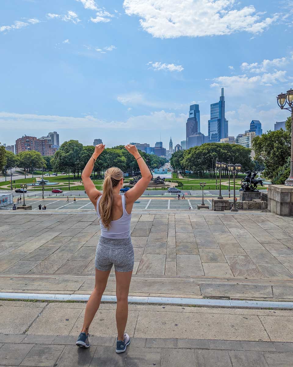 Bailey poses like Rocky at the top of the Rocky steps at the Philadelphia Museum of Art