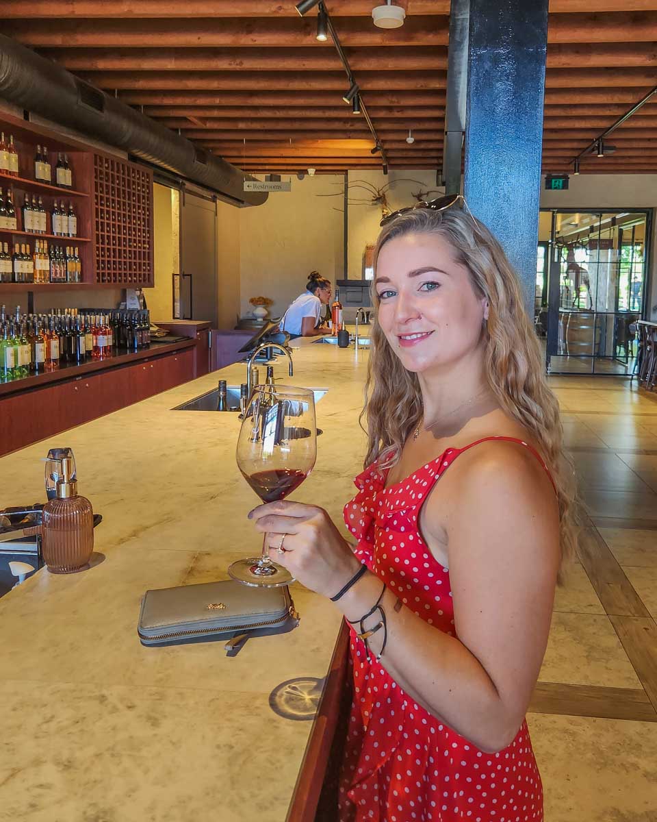 Bailey tastes a glass of wine in the Swan Valley while on a wine tour