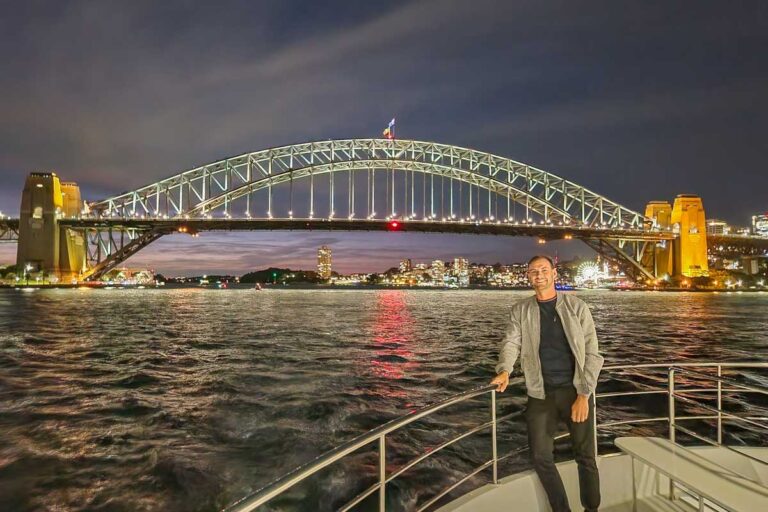 Daniel poses for a photo on a dinner cruise in Sydney with the Sydney harbour Bridge in the background