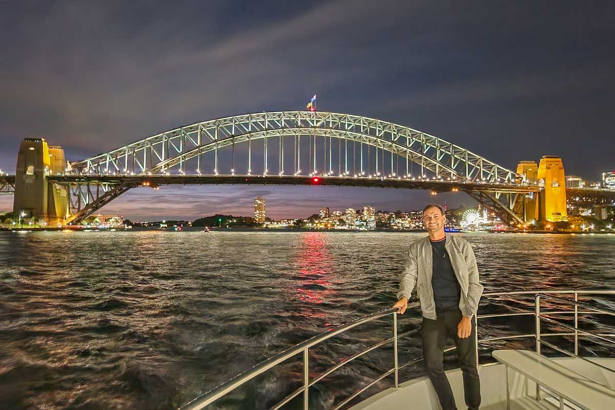 Daniel poses for a photo on the Journey Beyond the Cruise Sydney with the Sydney harbour Bridge in the background