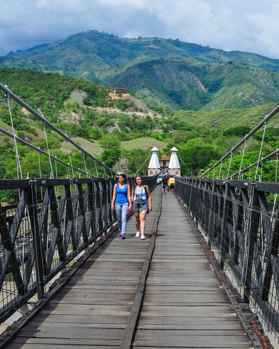 People walk the The Puente de Occidente in Santa Fe de Antioquia