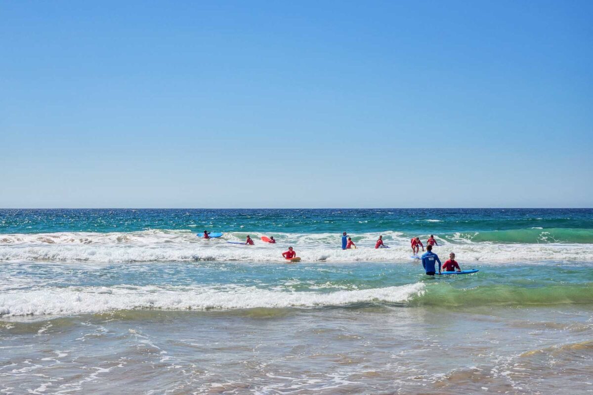 A group of people learn to surf at Manly Beach, Sydney