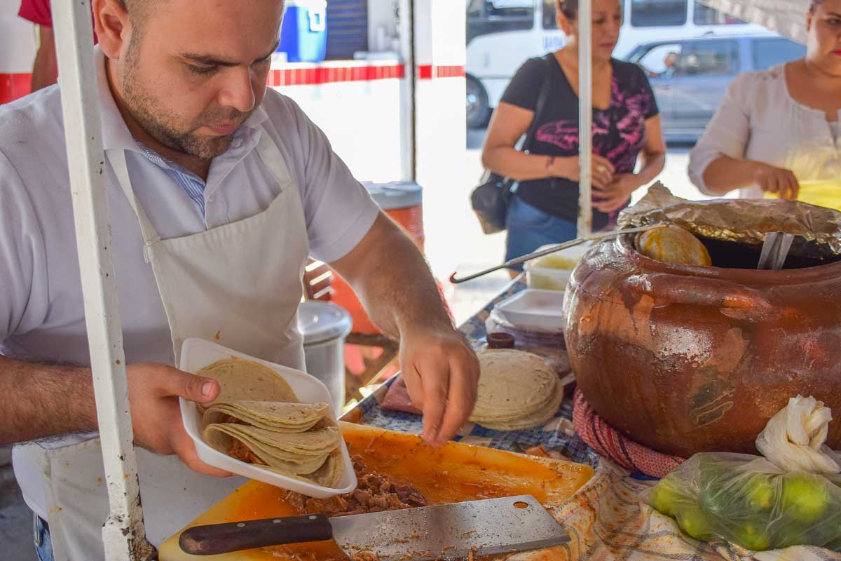 A taco stand worker prepaires Tacos Barbacoa in Playa del Carmen, Mexico