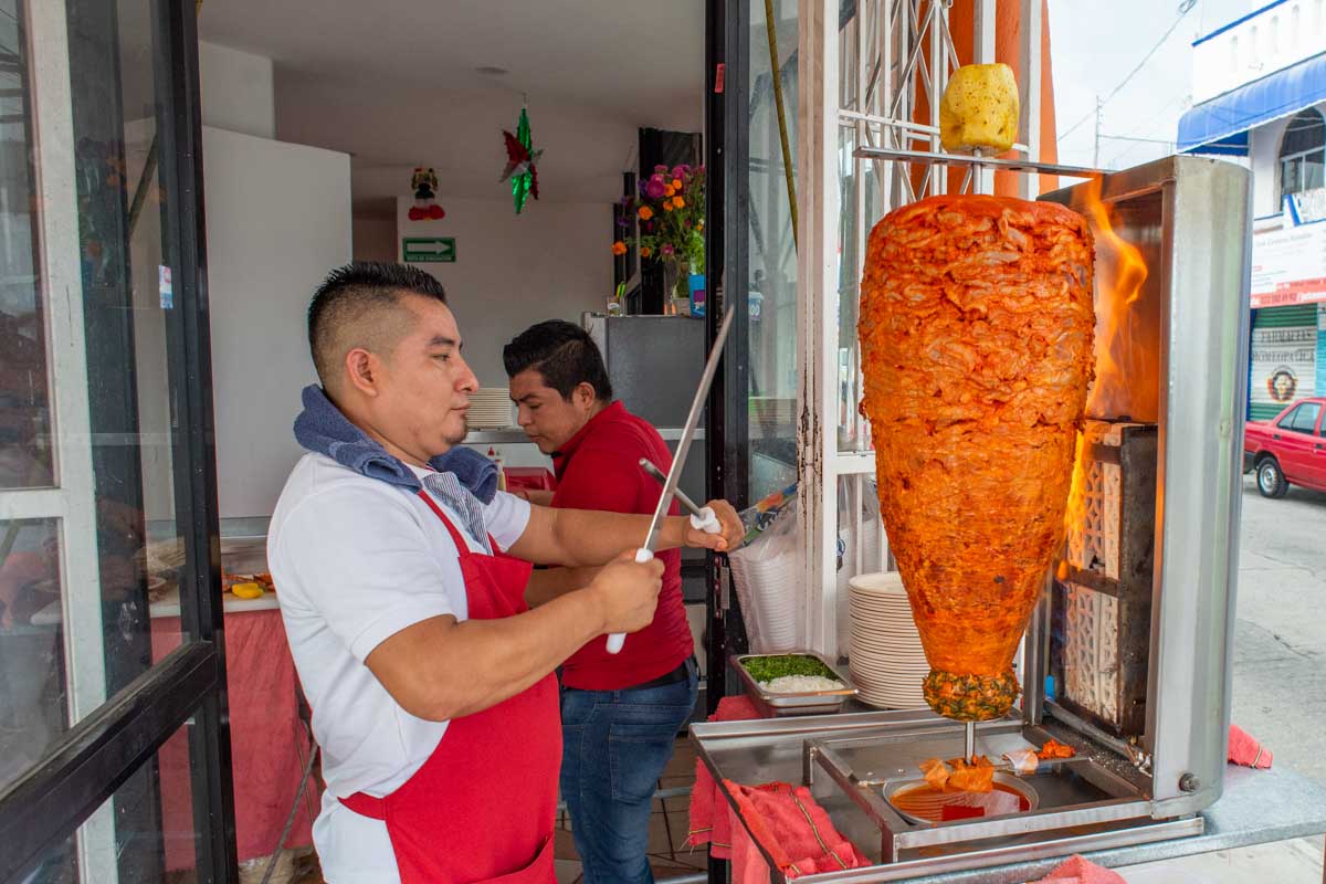 Al pastor tacos being cooked by a taco chef in Playa del Carmen, Mexico
