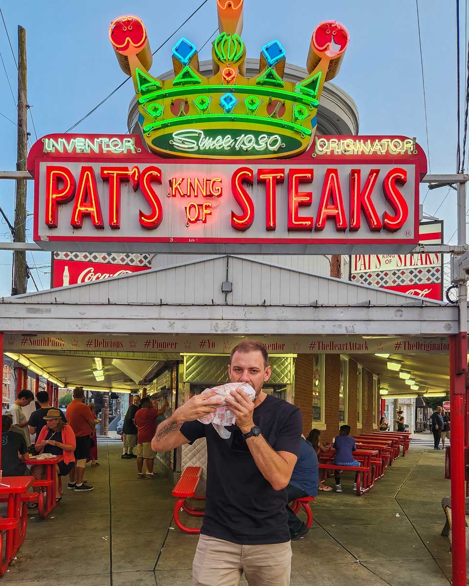 Daniel bites into a cheese steak at Pat’s King of Steaks in Philadelphia, USA