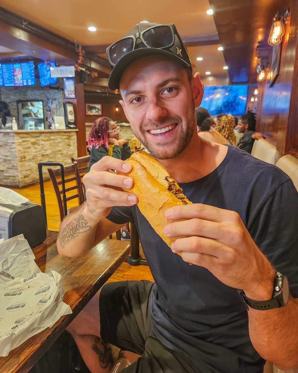 Daniel bites into a cheese steak in Oh Brother Philly