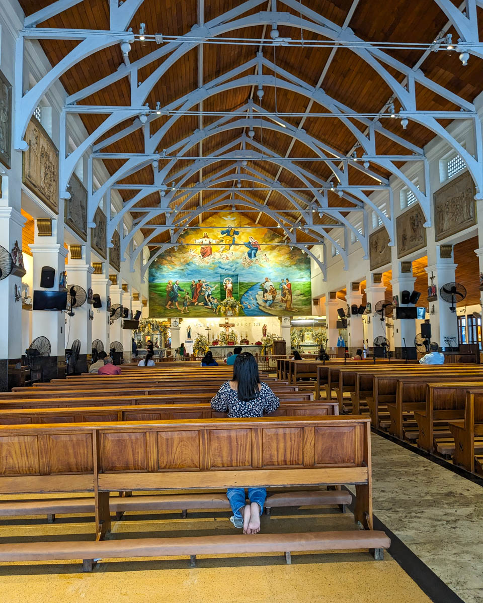 A Sri Lankian woman kneels at a pew praying in The Catholic Shrine of Saint Anthony Colombo, Sri Lanka