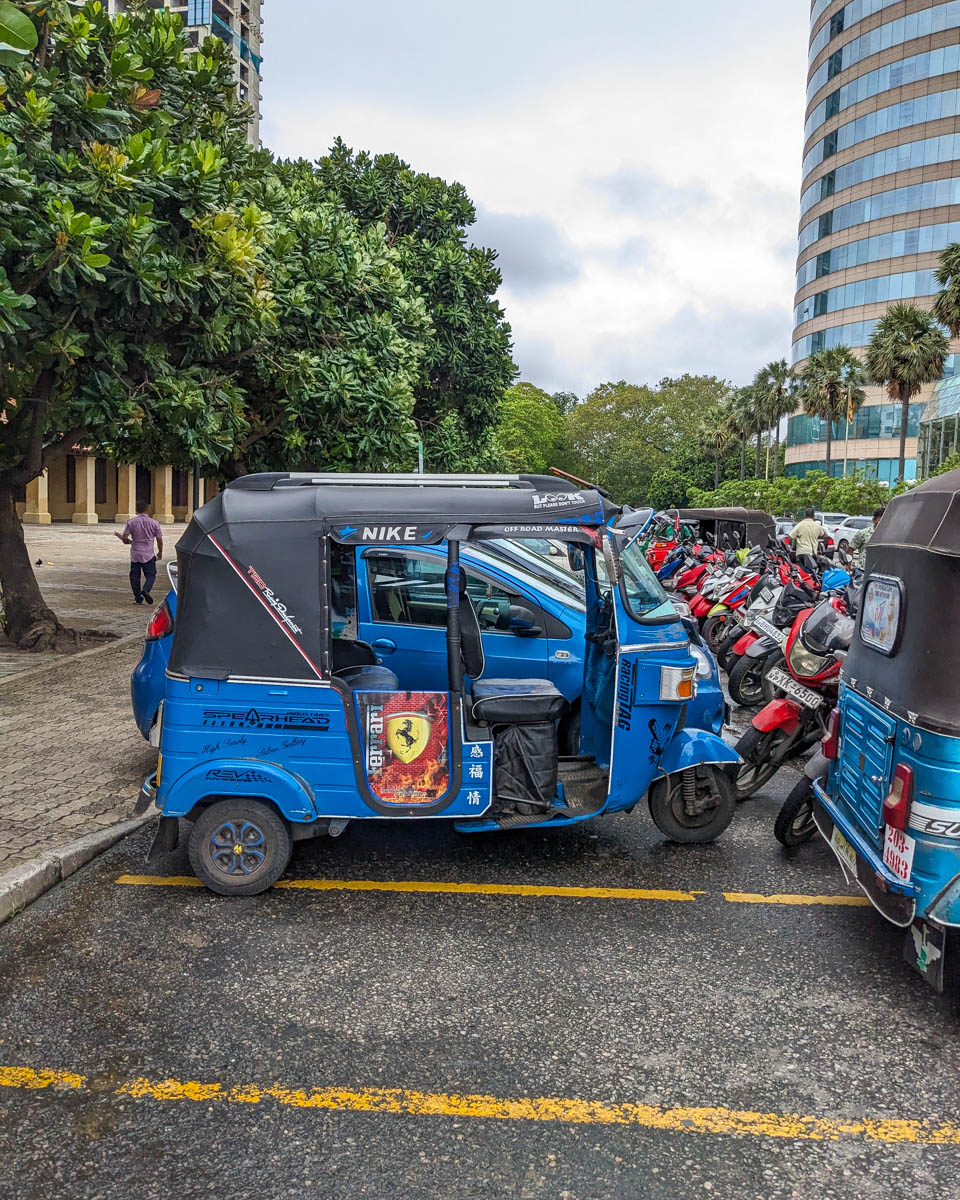 A blue tuktuk parked with other motorcycles that our guide took us around Colombo, Sri Lanka in